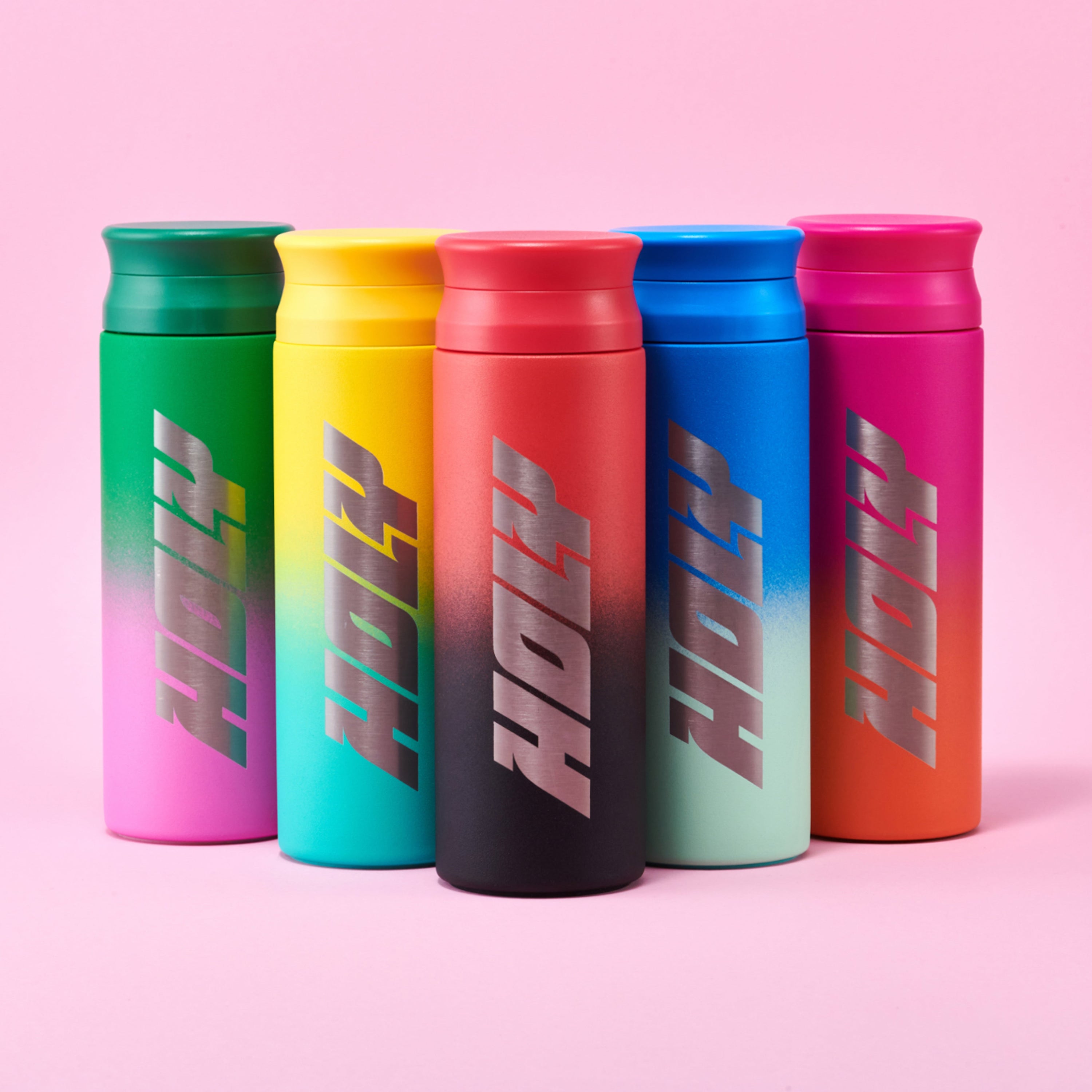 Fünf bunte Shaker mit dem Schriftzug "Holy" auf rosa Hintergrund.