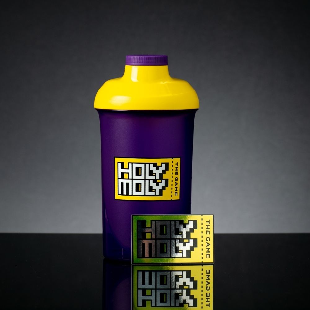 Lila Shaker mit gelbem Deckel und "Holy Moly" Text in Pixeloptik auf schwarzem Hintergrund.