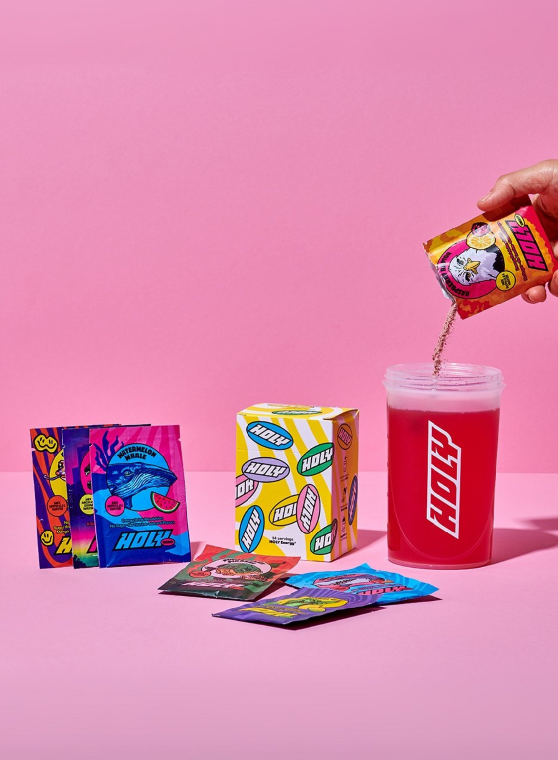 Verschiedene bunte Probepackungen, ein Karton und ein Shaker, in den gerade Pulver aus einem Sachet geschüttet wird.