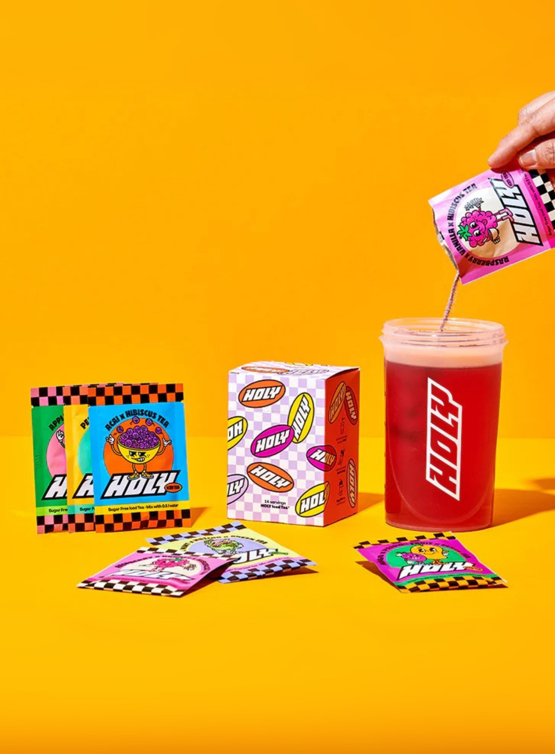 Pappdose mit rotem Getränk, daneben bunte Sachets und Pappbox auf orangem Hintergrund. Eine Hand schüttet ein Sachet in die Dose.